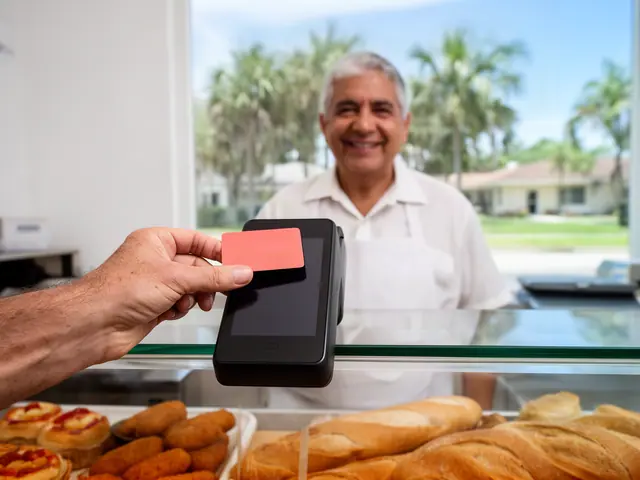 A customer taps a card on a counter terminal at a small Cuban bakery.